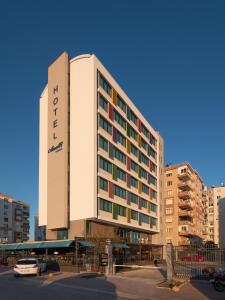 a hotel building with a car parked in front of it at Anelli Hotel in Antalya