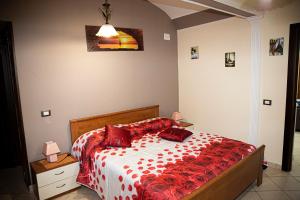 Un dormitorio con una cama con almohadas rojas. en Casa Vacanze Etna, en Linguaglossa