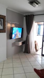 sala de estar con TV de pantalla plana en la pared en Apartamento quadra mar, en Balneário Camboriú