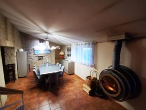 a kitchen and dining room with a wood stove at L'AUTHENTIQUE in Eurre