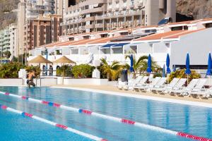 a woman is standing next to a swimming pool at Radazul Marina Seafront 12 in Radazul