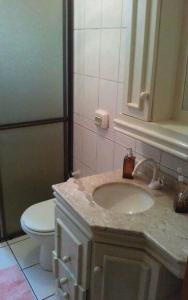 y baño con lavabo y aseo. en Apartamento quadra mar, en Balneário Camboriú