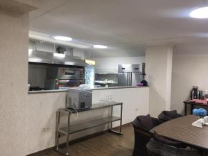 a kitchen with a counter and a table with chairs at Hotel Lazi in K'obulet'i