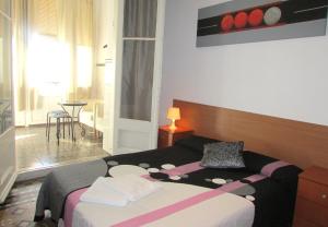 a bedroom with a bed with a pink and black blanket at Hostal Lima in Barcelona