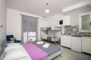 a bedroom with a large bed and a kitchen at Studios Tasos in Chrysi Ammoudia