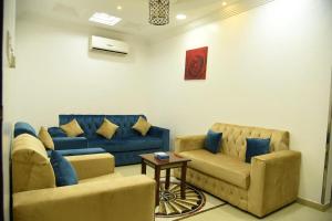 a living room with two couches and a table at شقق جنان المفروشة Jenaan Apartments in Najran