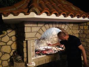 a man preparing food in a brick oven at HVAR BEACH VILLA in Jelsa