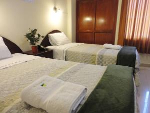 Habitación de hotel con 2 camas y toallas. en Hotel Torontel, en Ica