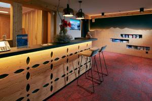 un bar con dos taburetes delante de un mostrador en Hotel Central Wolter - Grindelwald, en Grindelwald