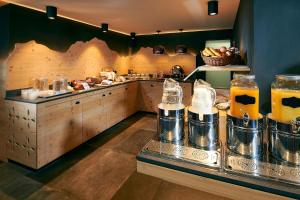 eine Küche mit einer Theke mit Speisen und Getränken in der Unterkunft Hotel Central Wolter - Grindelwald in Grindelwald