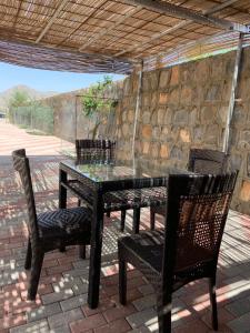 a black table and chairs on a patio at Stone Guest House in Al ‘Aqar