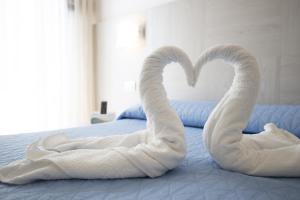 a bed with two swans made out of towels at Hotel Carillon in Bellaria-Igea Marina