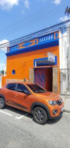 an orange suv parked in front of a building at Pousada Refúgio in João Pessoa