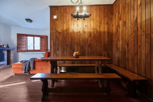 een houten kamer met een tafel en een bank bij Chiar di Luna Apartment in Roccaraso
