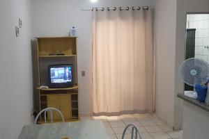 sala de estar con TV y cortina en Residencial Varanda dos Buritis, en Caldas Novas