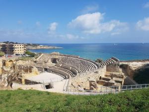 an ancient amphitheater with the ocean in the background at Fantástico apartamento al lado del Serrallo in Tarragona