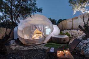 a large glass dome with a bed in a yard at Balloon Suites with Sky View in Nea Moudania