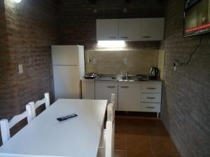 a kitchen with a white table and a white refrigerator at Los Cabre in San Pedro