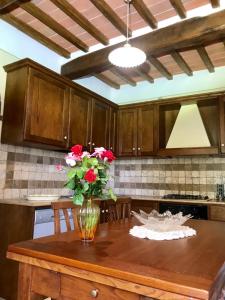 a kitchen with a table with a vase of flowers on it at Il Colle Rigomagno in Rigomagno