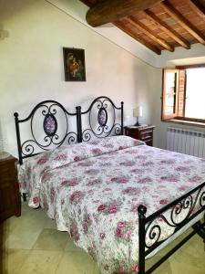 um quarto com uma cama grande e uma colcha floral em Il Colle Rigomagno em Rigomagno