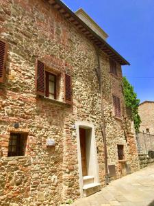 um antigo edifício de tijolos com janelas e uma porta em Il Colle Rigomagno em Rigomagno