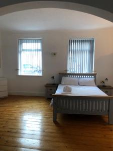 a bedroom with a large bed and two windows at Locke House in Newport