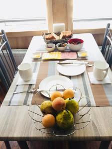 a wooden table with a plate of fruit on it at Hostal Origen Patagonia in Punta Arenas