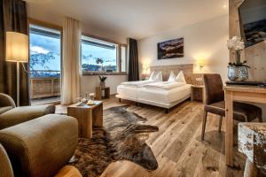 a bedroom with a bed and a living room at Golf- & Sporthotel Hof Maran in Arosa