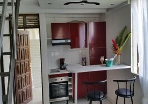 een keuken met rode kasten en 2 barkrukken bij SaS NEMO in Lamentin