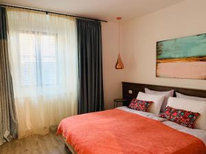 1 dormitorio con 1 cama con manta roja y ventana en Happy Casa Oldtown Boutique, en Koper