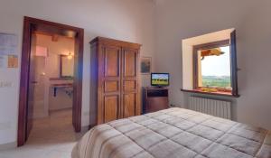 ein Schlafzimmer mit einem Bett, einer Kommode und einem TV in der Unterkunft Il Girasole Country House in Camerano
