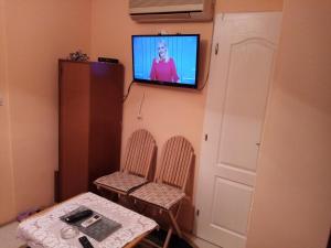 a room with two chairs and a television on a wall at Guest house Mirijevski Konak in Belgrade