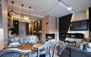 - un salon avec un canapé, une table et une cheminée dans l'établissement Szymoszkowa Residence Luxury Apartment, à Zakopane