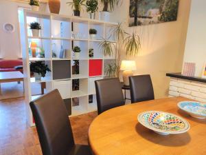 a dining room with a table and chairs and a shelf with plants at Groepswoning Domus Nimma, also work friendly in Nijmegen