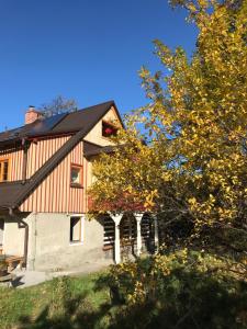 ein Haus mit schwarzem Dach und einigen Bäumen in der Unterkunft Domicil Alma in Szklarska Poręba