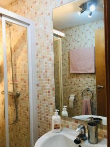 ein Bad mit einem Waschbecken, einer Dusche und einem Spiegel in der Unterkunft Casares Vacations in Casares