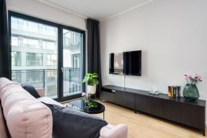 - un salon avec un canapé et une télévision dans l'établissement Apartament Małe Garbary, à Poznań