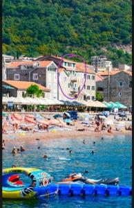 un gruppo di persone in acqua in spiaggia di Apartments Teodora Obala a Petrovac na Moru