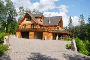 una casa de madera con una entrada delante de ella en Le Domaine du Lac Saint Charles, en Quebec