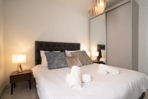 una camera da letto con un grande letto bianco con asciugamani sopra di HolySuite Even Israel a Gerusalemme