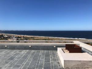 a bench sitting on top of a building overlooking the ocean at Apartamento en Sierra Ballena 2, vistas unicas in Punta del Este