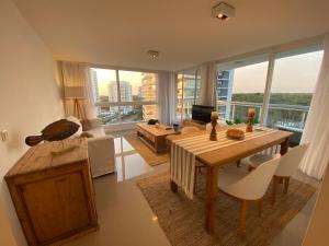 a living room with a table and a living room with a view at Torre One II Punta Del Este in Punta del Este
