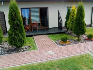 a house with a garden with trees and a patio at luna in Gąski