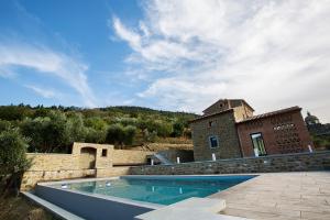 a house with a swimming pool next to a building at Fonte al Vento in Cortona
