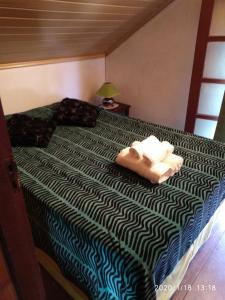 a bedroom with a bed with two towels on it at Bon Bini in Punta Del Diablo