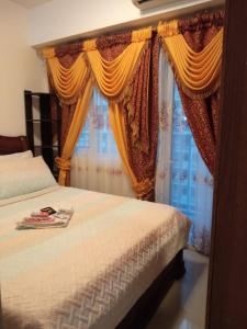 um quarto com uma cama e uma janela com cortinas em Jones Shore Residences em Manila