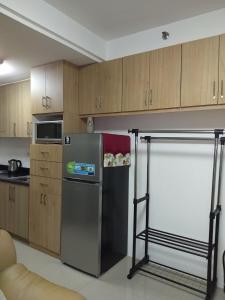 uma cozinha com um frigorífico de aço inoxidável e armários de madeira em Jones Shore Residences em Manila