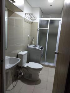 uma casa de banho com um WC, um lavatório e um chuveiro em Jones Shore Residences em Manila