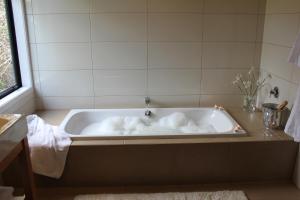 uma banheira com toalhas brancas na casa de banho em Te Kahu em Whangarei