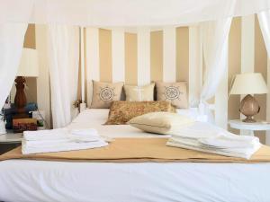 a white bed with white sheets and pillows on it at Le Terrazze in Otranto
